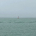 sea, haze, two sails in distance